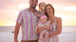 Family with young children taking a photo on the beach in Florida on vacation