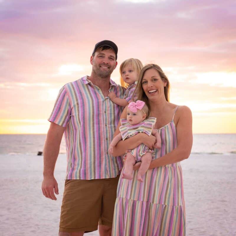 Family with young children taking a photo on the beach in Florida on vacation