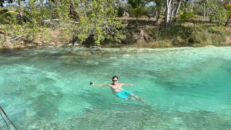 man swimming in the current of Los Rapidos in the Bacalar Lagoon