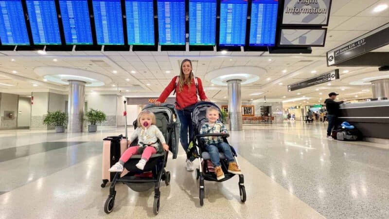 mom at airport with two kids in strollers Joolz Aer and Babyzen Yoyo