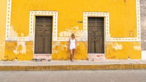 woman standing against a yellow building in Izamal Mexico