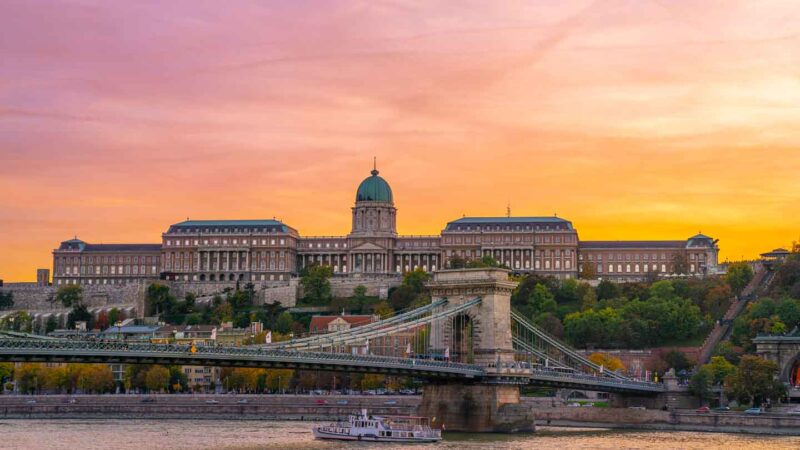 exterior view of the Budapest History Museum at sunset with the chain bridge in the foreground