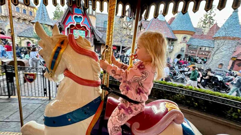 toddler girl riding the carousel at Disney