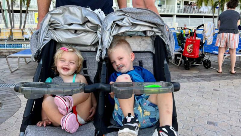 Two toddlers in the Zoe double stroller smiling