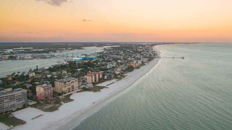 Aerial View of Ft Myers Beach at sunset with white sand and orange colors in the sky