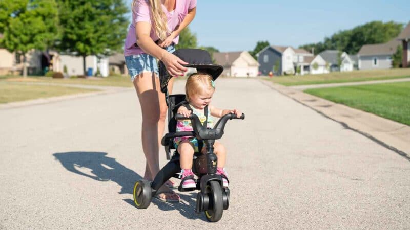 Girl riding a black and gold Doona Liki Trike