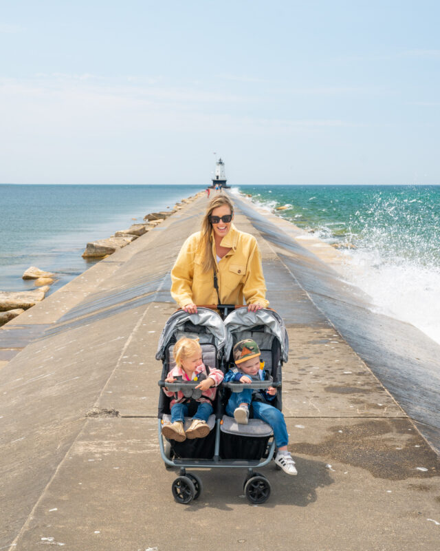 Mom and two toddlers in Zoe Stroller double on breakwall in Ludington Michigan