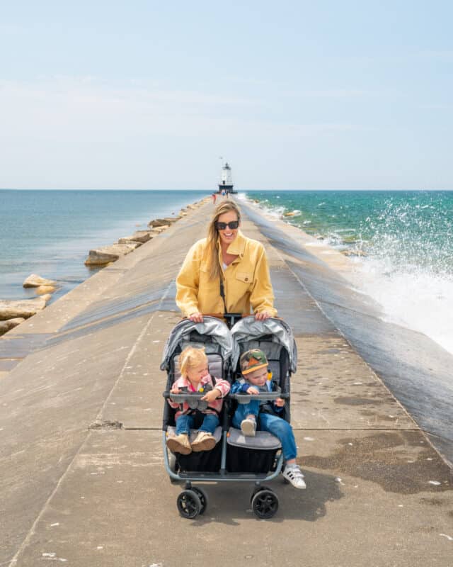 Mom and two toddlers in Zoe Stroller double on breakwall in Ludington Michigan