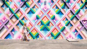 woman walking in a colorful dress in front of the vibrant murals of Wynwood Walls one of Miami's top tourist attractions