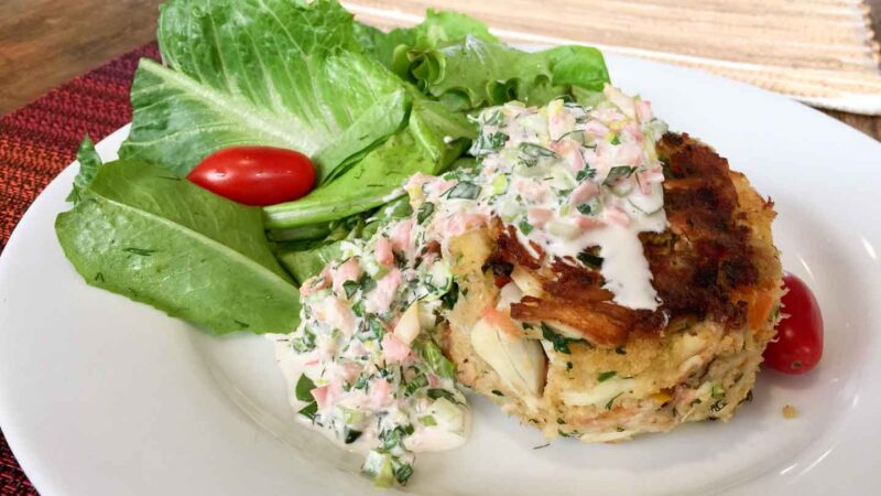 crab cakes on a plate with a lettuce leaf