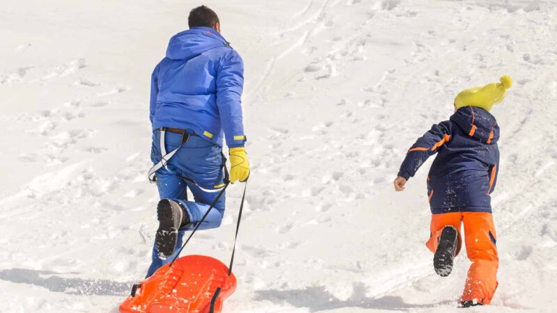 man climbing up a sledding hill in Wisconsin