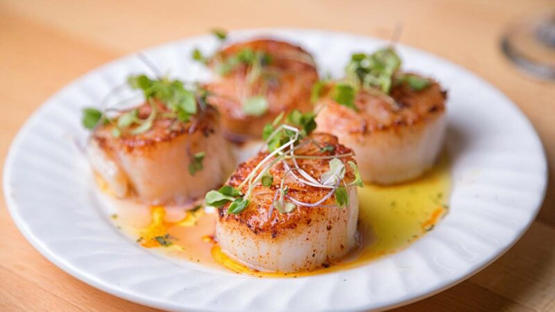 seared scallops in butter on a plate at restaurant
