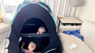 two kids one in the SlumberPod blackout tent and another opening it