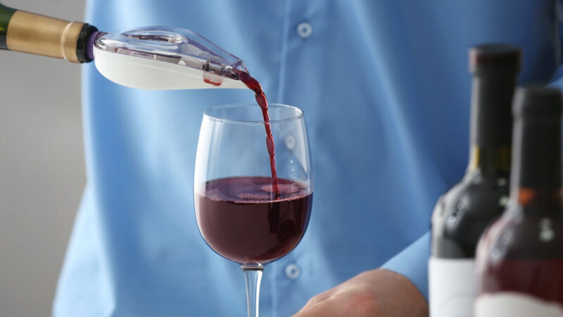 Sommelier derramando vinho tinto em copo
