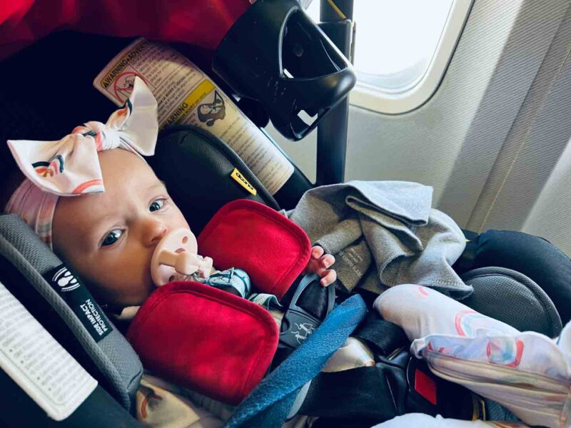 baby girl in Doona car seat stroller on an airplane