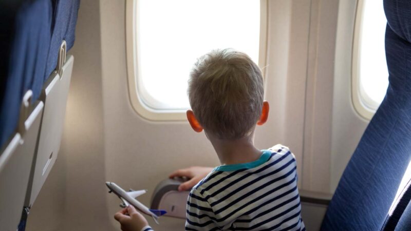 toddler on airplane with toy