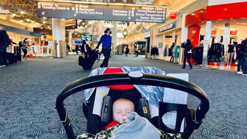 baby sleeping in Doona at airport