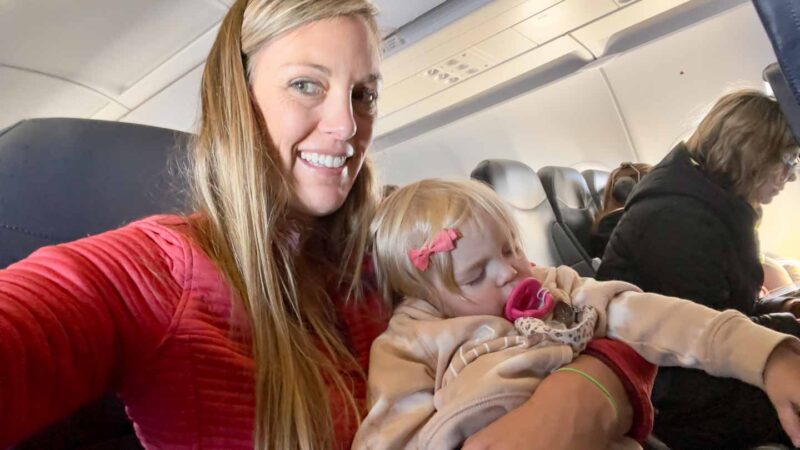 mom and toddler flying sleeping on an airplane