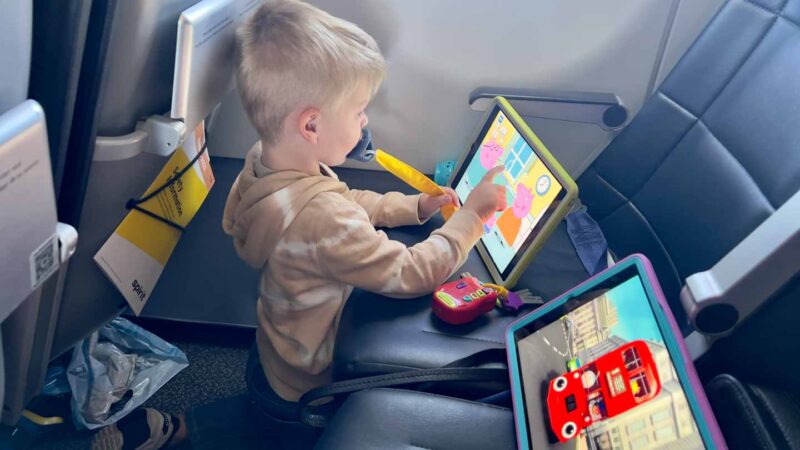 toddler flying playing games on iPad