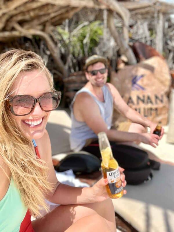 couple drinking a bear at a Tulum Beach Club in Tulum Mexico