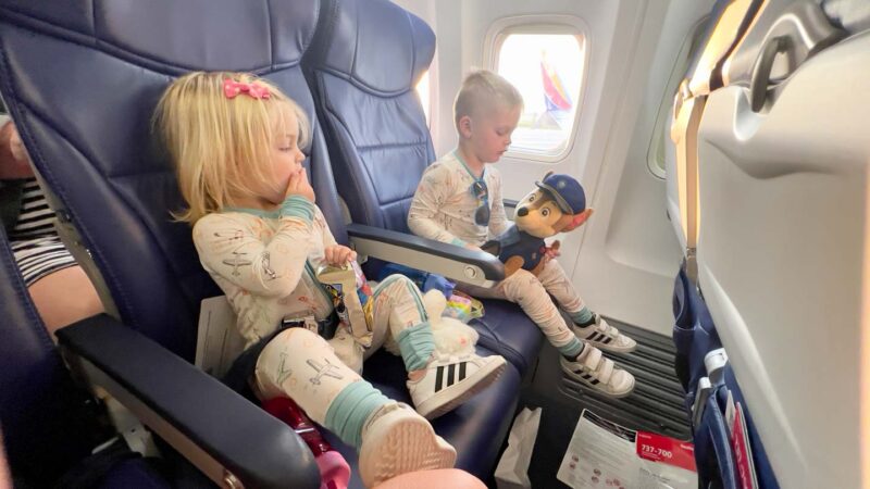 two toddlers sitting in an airplane