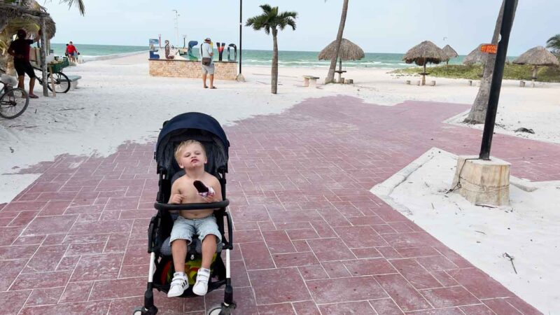 Toddler in Babyzen Yoyo stroller eating popsicle in Mexico