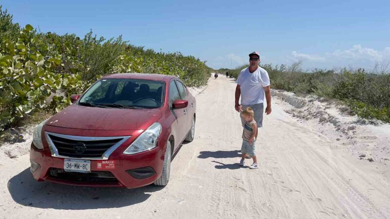 father and son and rental car by the sandy road from El Cuyo to Las Coloradas Mexico