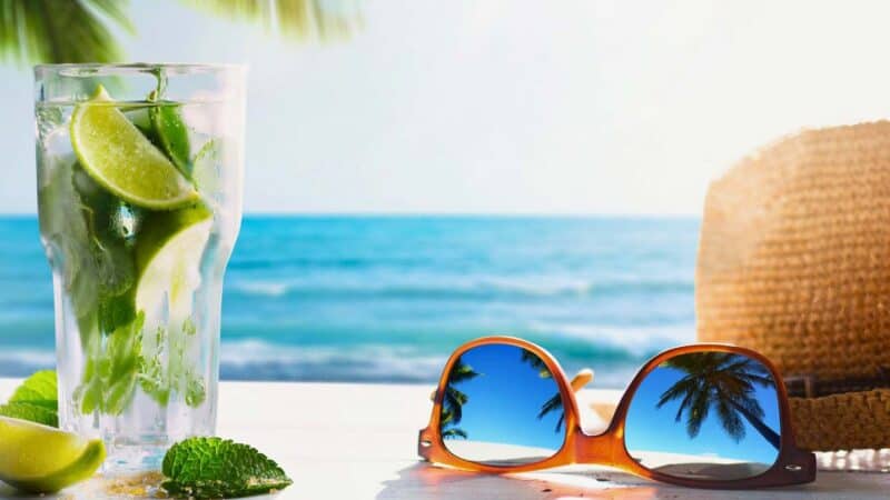 mojito on the beach with sunglasses and a hat