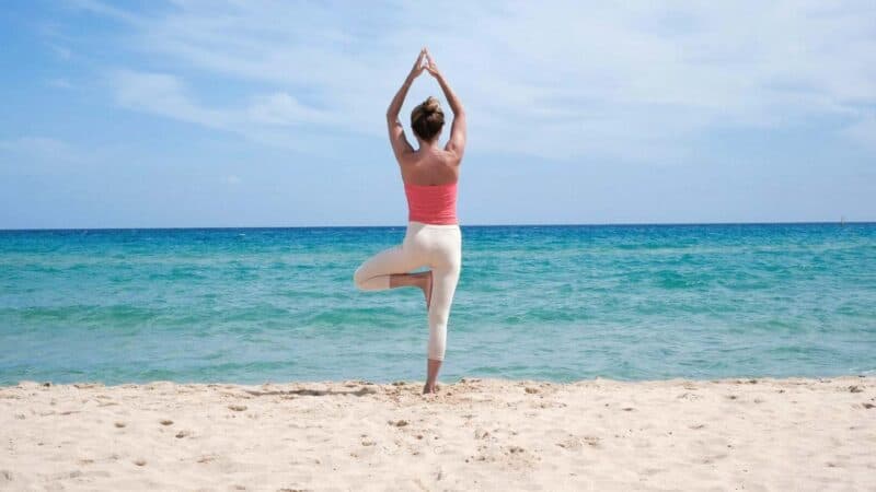 woman doing yoga on the beach