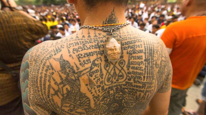 Thai mans back covered in traditional thai tattoos Sak Yants