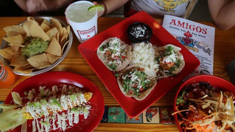 table full of food at Amigos Tortilla Bar tacos, corn, chips and salasa, a drink one of the Best Key West Restaurant