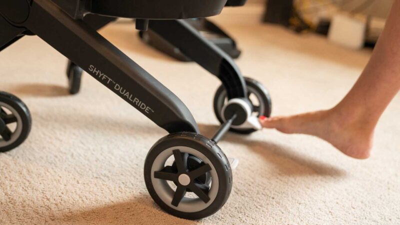 woman's foot pressing the break on the DualRide car seat stroller