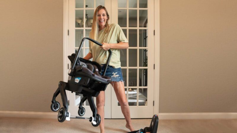 woman holding the Evenflo Shyft DualRide infant carseat stroller combo