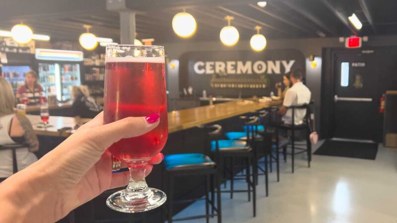 Woman holding a red beer at Ceremony brewing - breweries in Fort Myers