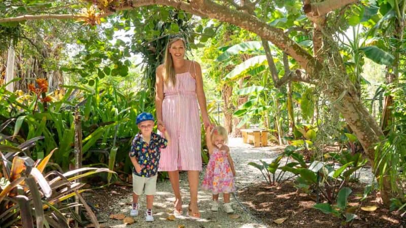 Woman and two kids walking in the lush tropical gardens of the Wonder Gardens in Bonita Springs, FL