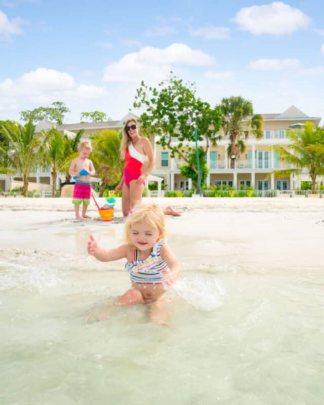 little girl playing in the ocean with mom and brother on the beach in Jamaica