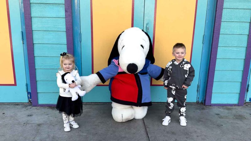 two children standing with Snoopy