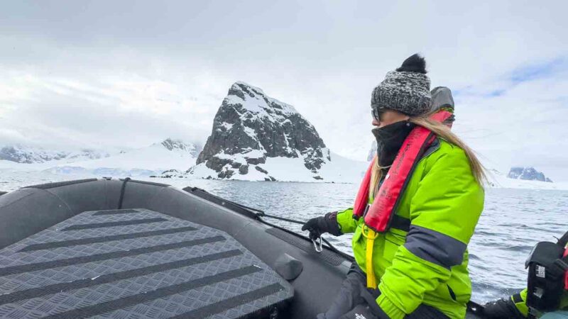 woman on zodiac in Antarctica wearing hat, gloves, jacket, and all the best clothes for Antarctica