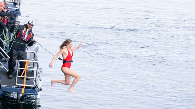 woman jumping in the ocean doing the polar plunge in Antarctica 